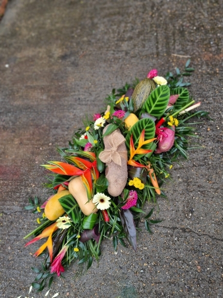 Caribbean funeral Coffin Spray with mixed tropical flowers and veggies done by florist in Bromley for free local delivery 