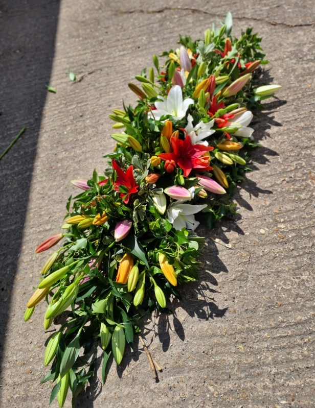 mixed asiatic lilies coffin spray made by Blooms and Candy florist