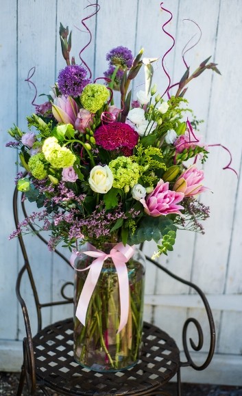 Beautiful arrangement of lovely flowers in large 30cm tall glass vase to include pink lily and viburnum arranged by florist in Hayes, Bromley