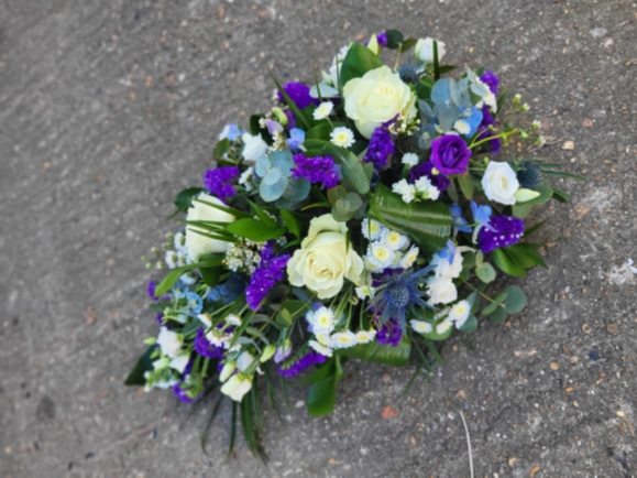 Mixed flowers teardrop to include white roses and purple limonium, lisantuh, delphinims, thisle and eucalyptus by Blooms and Candy Florist from Bromley