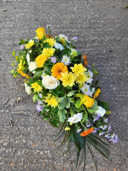 Compact look teardrop to include white roses, daisies, chrysanthemums, yellow daisies, roses and lilac fillers by Blooms and Candy Florist