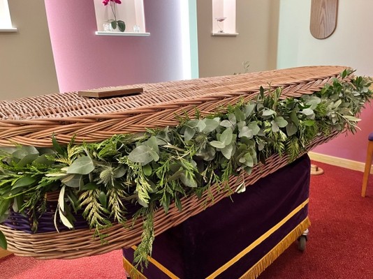 Wild looking funeral garland around coffin installed by local florist in Bromley