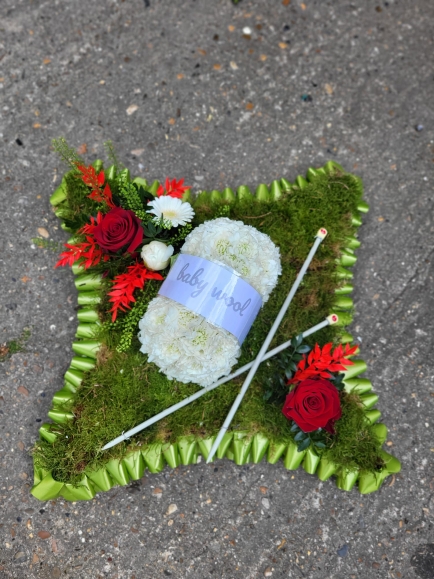 Any object or animal can be presented on a mossed cushion for a funeral. Made by Blooms and Candy