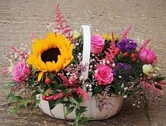 Vibrant flowers funeral basket to include pink roses and sunflowers