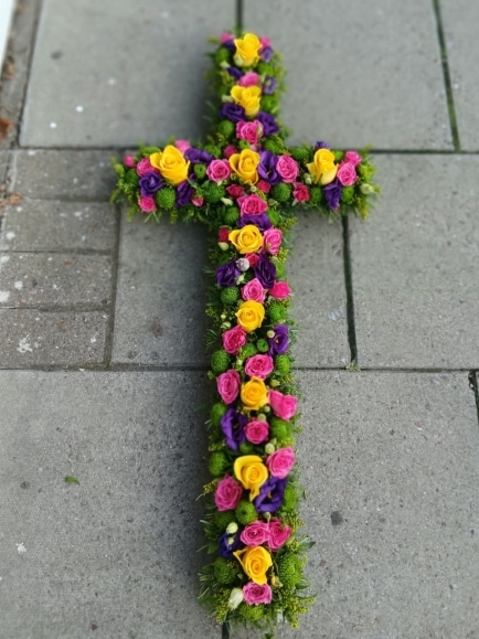 Vibrant funeral flowers cross made of fresh flowers by florist in Bromley, Kent, UK