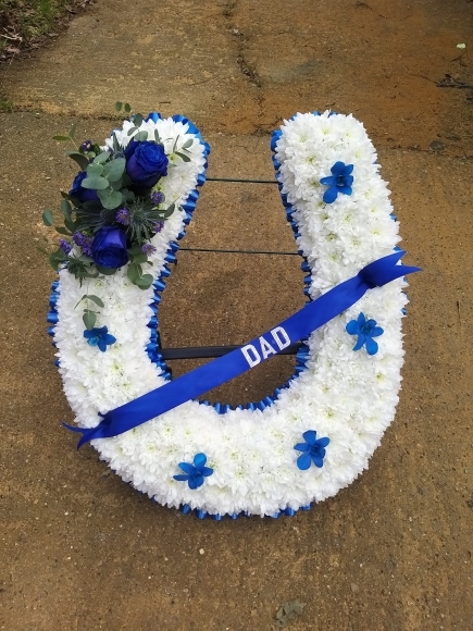 2D Horseshoe tribute with metal stand. Colours of ribbon and sprays can be changed By Blooms and Candy Florist