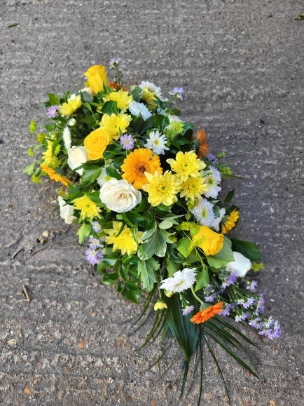 Compact look teardrop to include white roses, daisies, chrysanthemums, yellow daisies, roses and lilac fillers by Blooms and Candy Florist