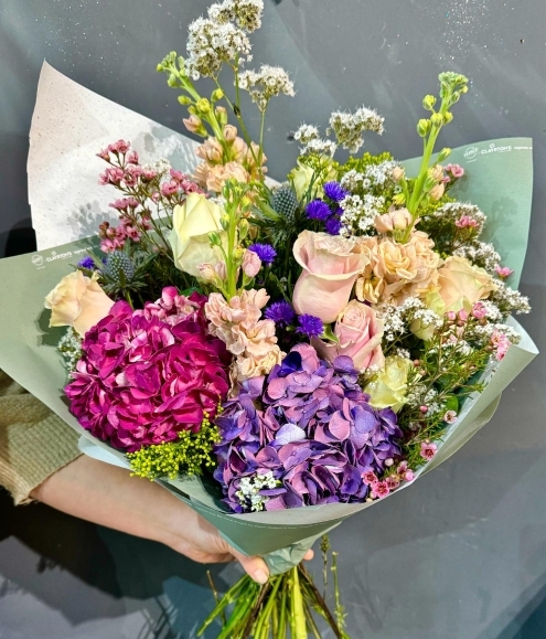 Let us pick up the best stems and crest this stunning compact wrap of luxury stems. Wrap mixed colours to include hydrangeas, scented stock, garden fillers, gypsophilium, roses.  flowers wrap in eco paper and tied with a bow. Made by florist in Hayes,  Bromley, Kent