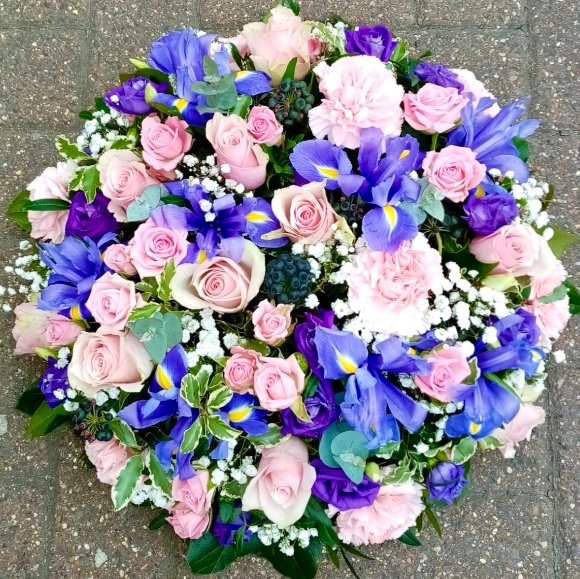 Pink roses and iris funeral spray in the shape of posy by florist in Bromley, Kent