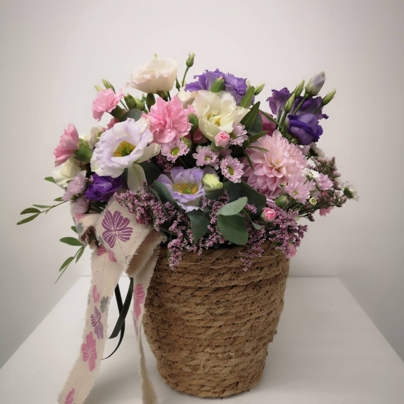Pastel flowers round basket posy arrangement to include roses, lisanthius, seasonal flowers