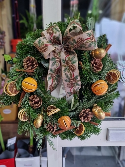 Bespoke made Christmas door wreath woth pines and oranges by Blooms and Candy Florist