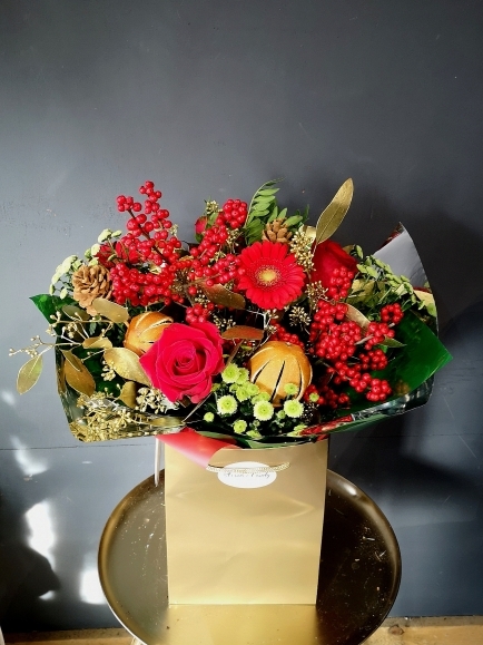 Christmas nfresh flowers bouquet to include Ilex and red roses arranged by local florist in Bromley