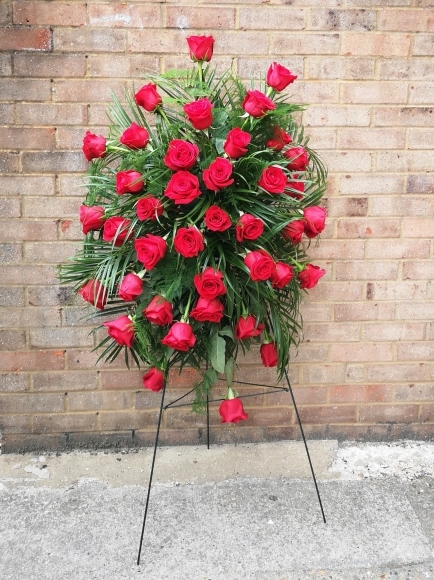 Red roses funeral spray on easel, service flowers, pedestal