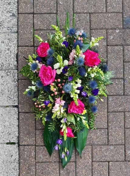Scotish theme funeral spray with Thisle and hot pink roses made by local florist in Bromley for delivery in Bromey, Kent, UK