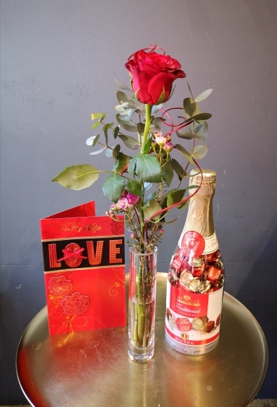 Single red rose in a bid vase with truffle chocolate bottle made by florist in Bromley, Hayes for Valentine's