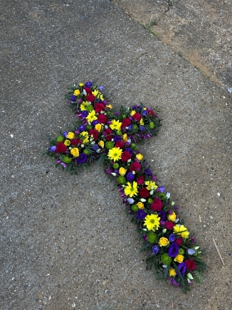 Vibrant funeral flowers cross made of fresh flowers by florist in Bromley, Kent, UK