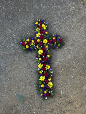 Vibrant funeral flowers cross made of fresh flowers by florist in Bromley, Kent, UK