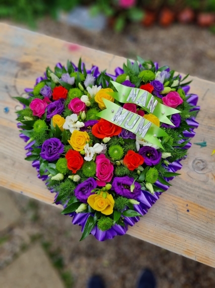 Funeral solid, full heart tribute made of deep purples, green, deep pink colours made by florist in Bromley for free delivery in Bromley, Beckenham, Croydon, Orpington, Sidcup, Pets Woods, Biggin Hill, Chislehurst 